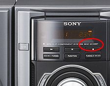 Abbildung einer Systemanlage in einem Bücherregal – Position der Modellbezeichnung auf der Vorderseite des Haupt-Players.